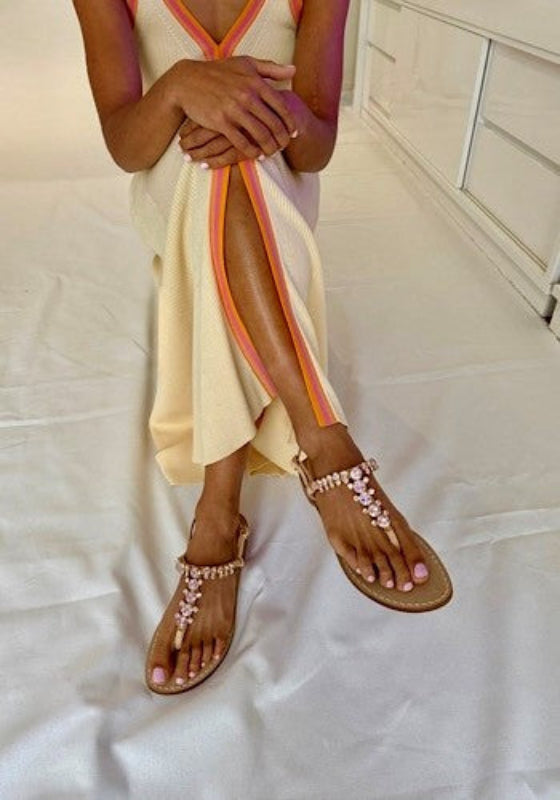 pink sparkly sandals on feet of person in cream dress