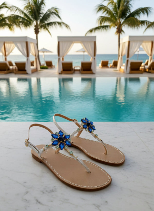 White sandals with blue embellishments poolside.