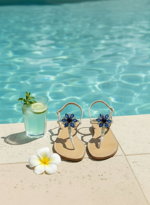 white and blue sparkly luxury sandals next to a pool