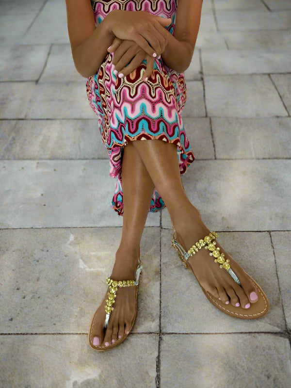 Girl wearing a colorful dress and silver yellow sparkly swarovski crystal sandals 