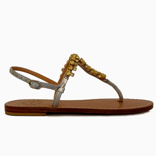 Silver leather sandal with gold embellishments on a white background