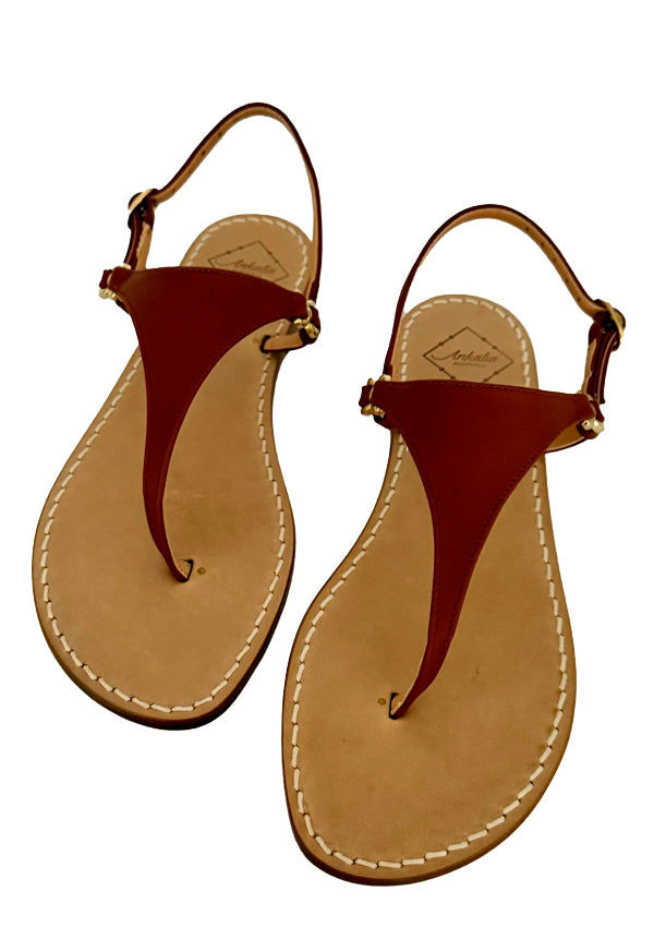 Pair of brown tan flat leather sandals with Italian leather soles on a white background
