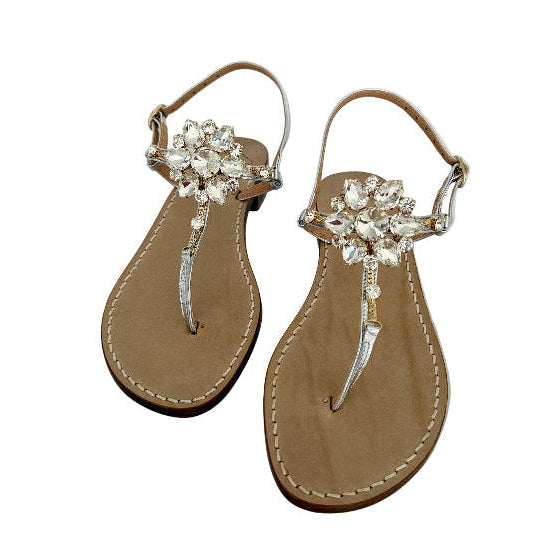 Pair of silver sandals with Swarovski crystal embellishments on a white background.